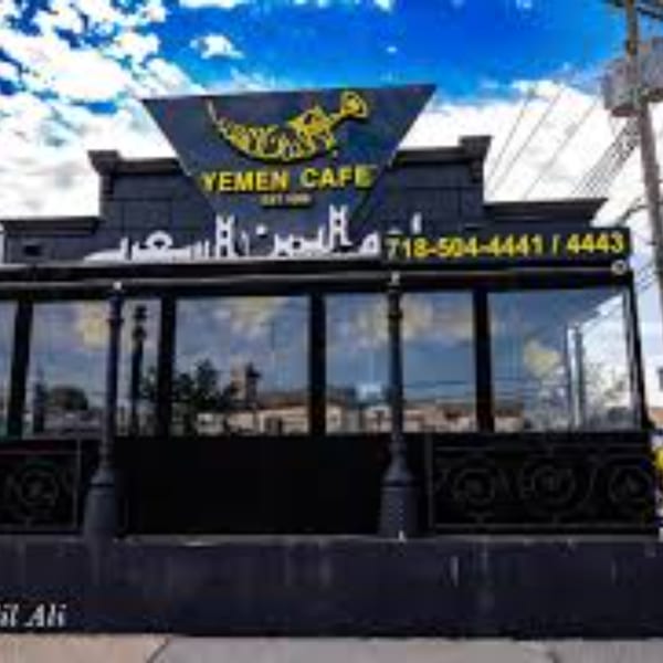 Exterior of Yemen Cafe & Restaurant with a black facade, large windows, and a prominent sign.