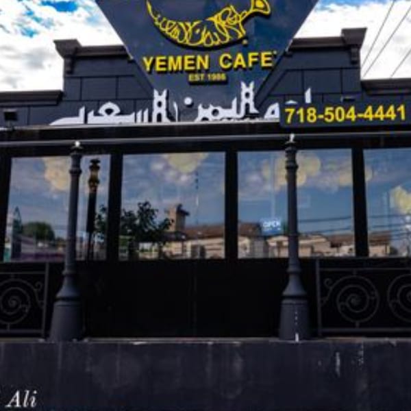 Exterior of Yemen Cafe & Restaurant, a dark building with large windows and a prominent sign.