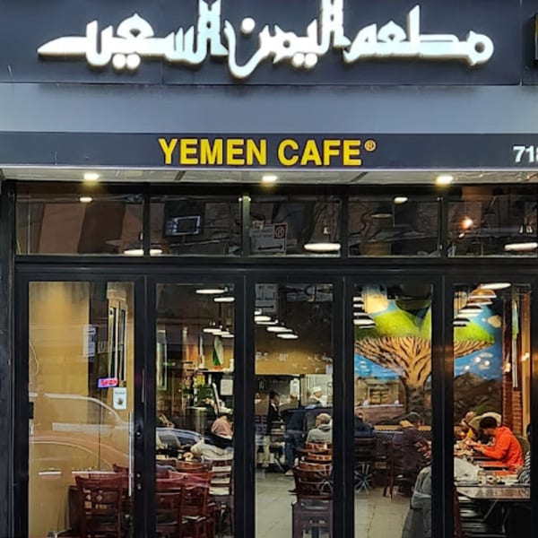 Exterior view of Yemen Cafe & Restaurant with its sign and patrons visible through the windows.