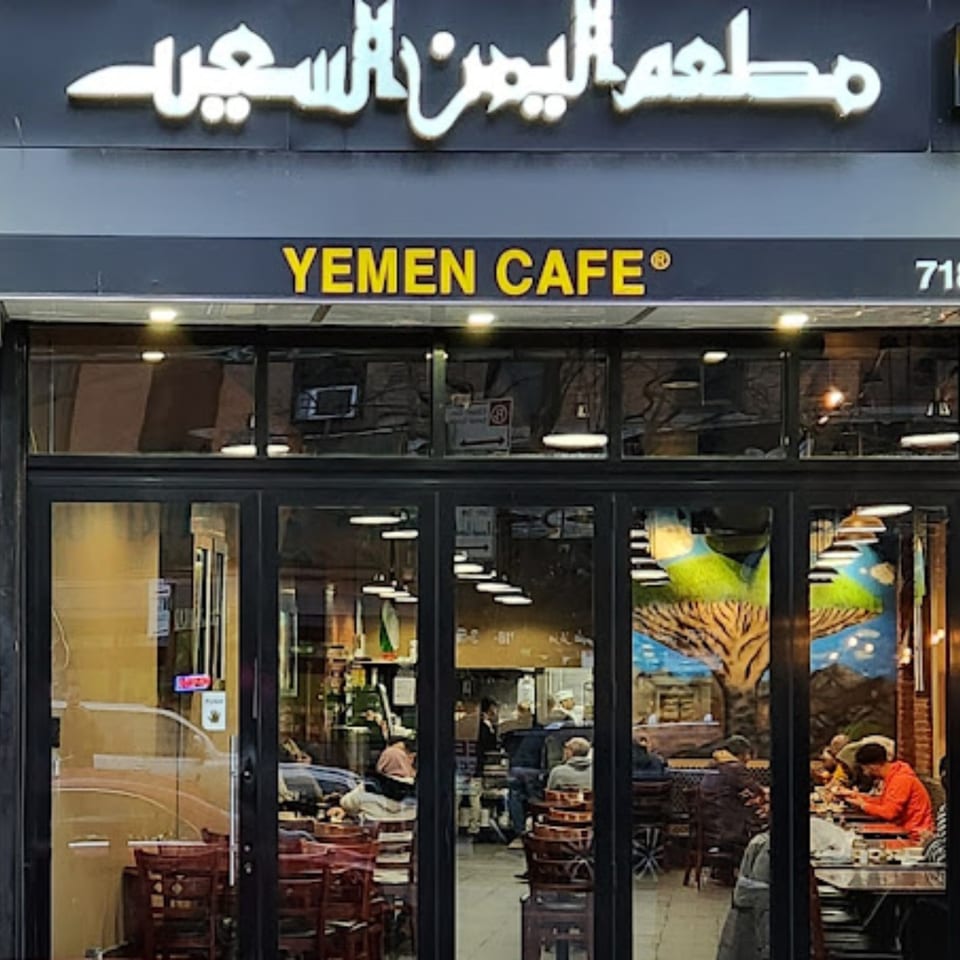 Exterior view of Yemen Cafe & Restaurant with its sign and patrons visible through the windows.